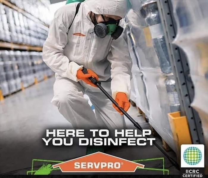 Suited employee spraying disinfectant