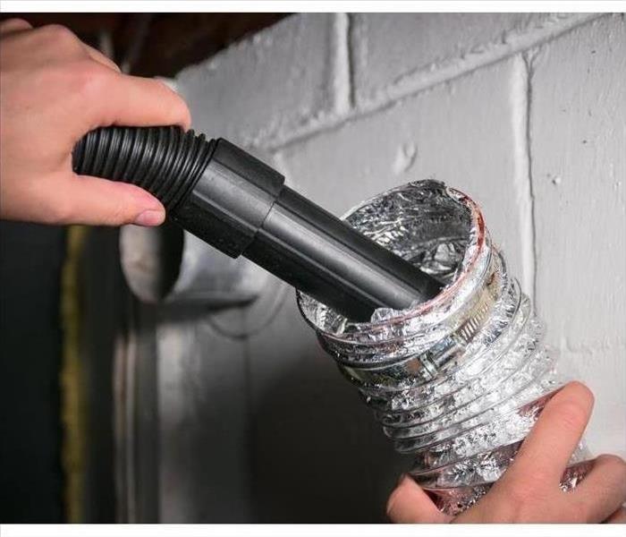 Photo of a dryer vent being cleaned. 