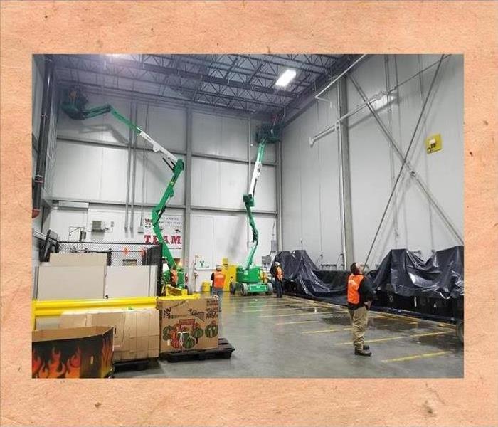 SERVPRO using high-lifts to clean a warehose