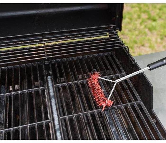 Photo of a grill being cleaned 